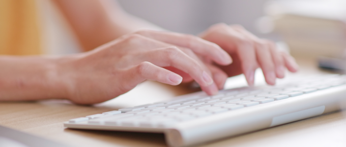 hands typing a summary on keyboard